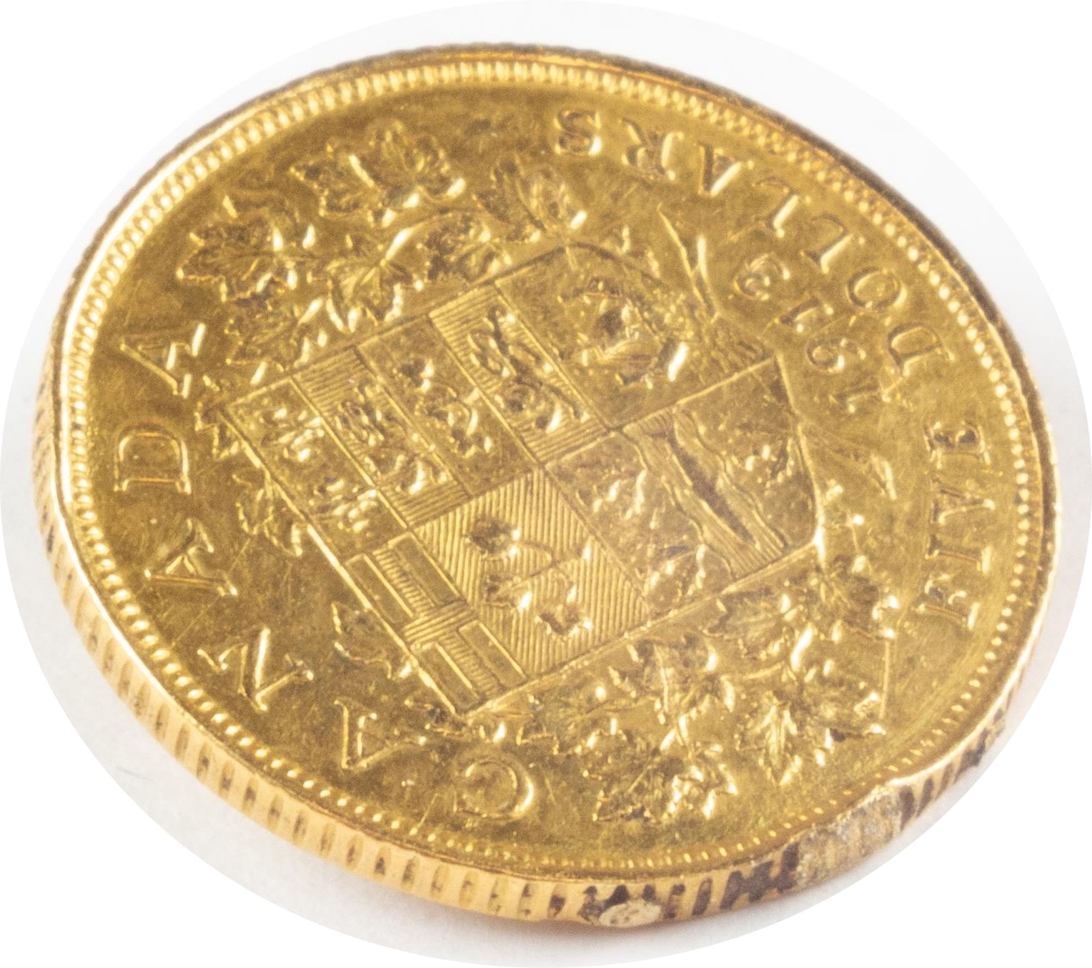 Close-up of the edge of a gold coin showing traces of jewelry use